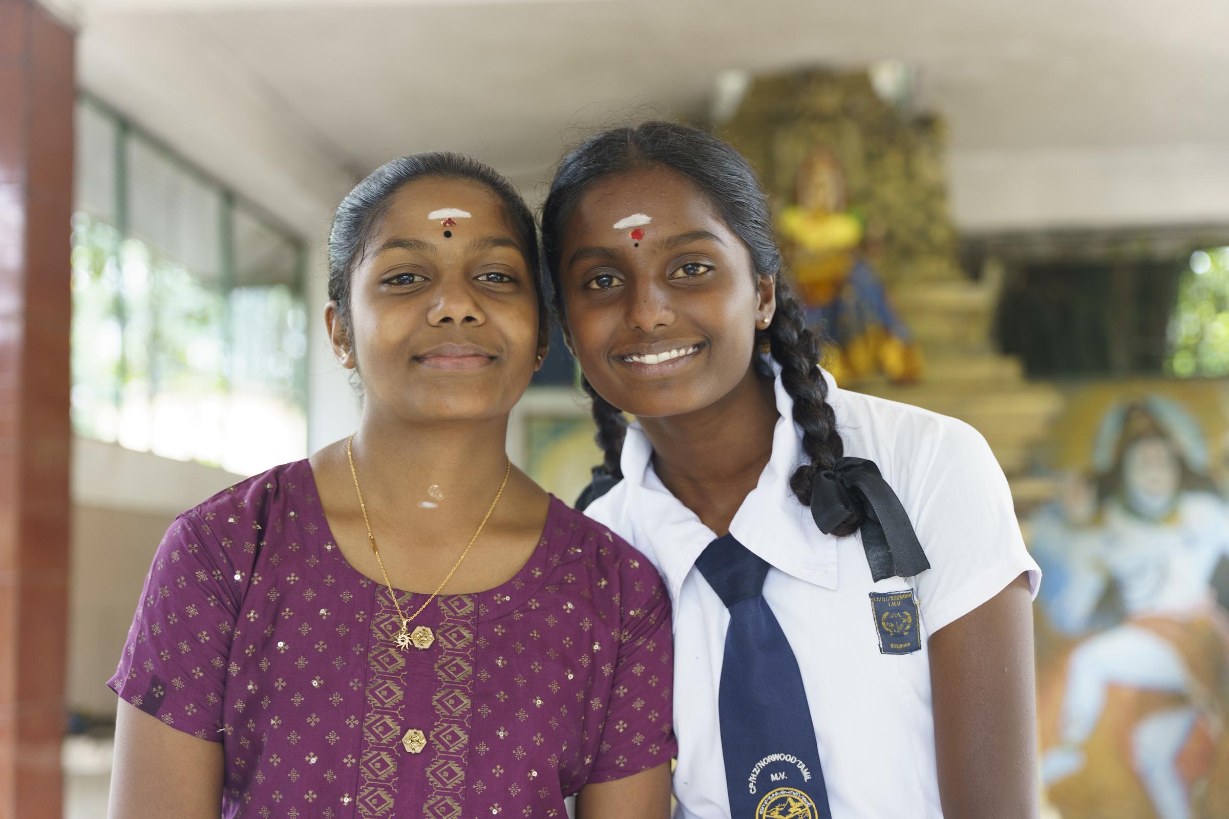 Zwei Freundinnen stehen lächelnd nebeneinander, Kopf an Kopf (Foto: Christian Nusch)