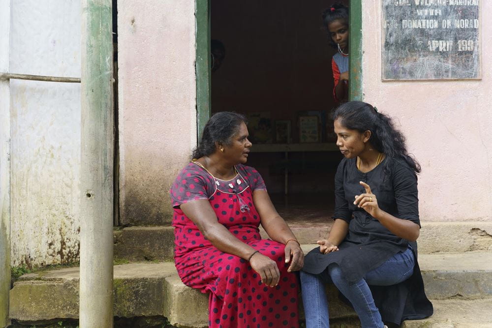 Eine Mitarbeiterin des Kindernothilfepartners spricht mit einer Teepflückerin (Quelle: Christian Nusch) Aruniya Jotikumar von TLV besucht die Teepflückerinnen, um mehr über ihren Alltag zu erfahren und sie zu unterstützen (Foto: Christian Nusch)