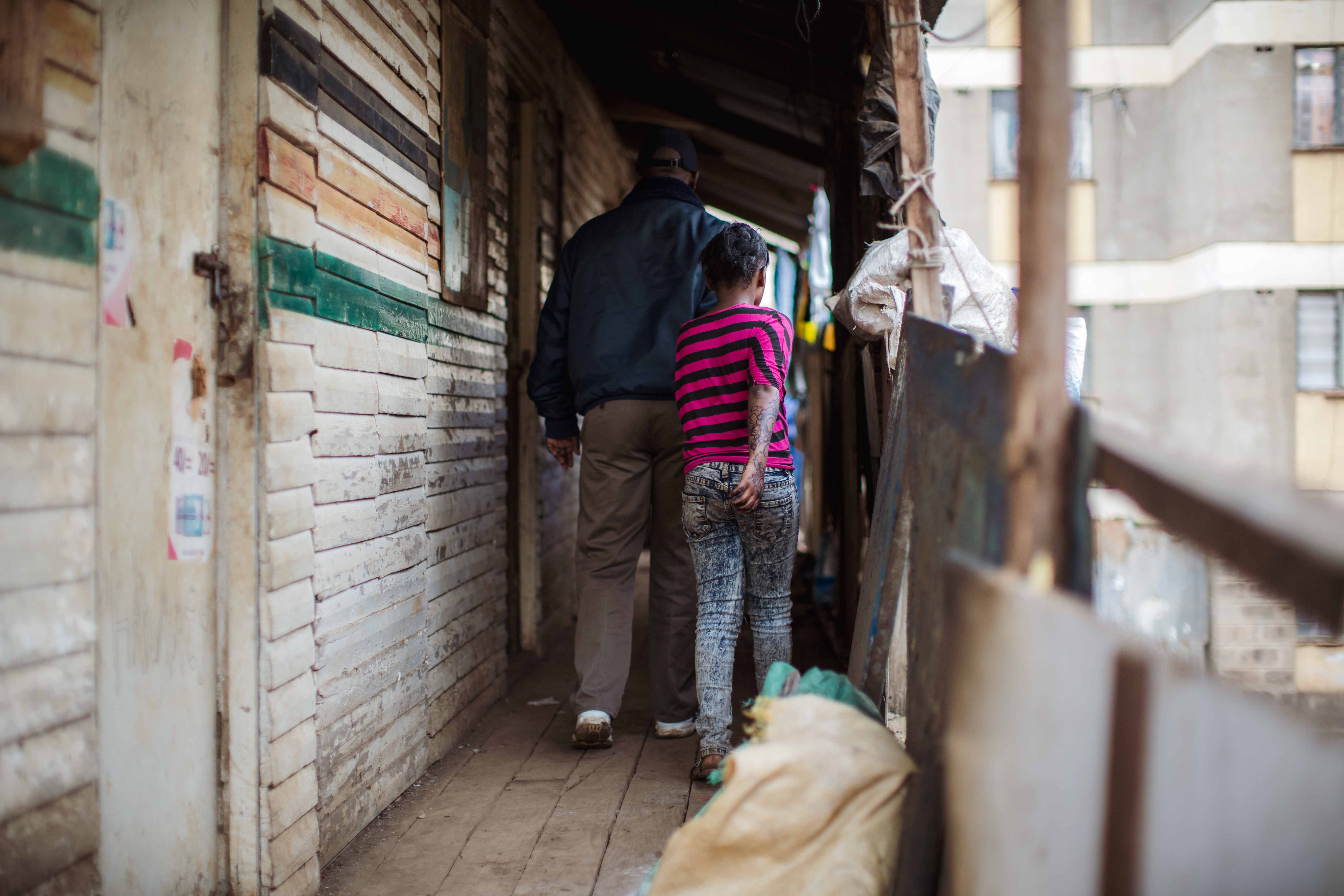 Ein Mann zieht ein Mädchen am Arm durch einen Flur hinter sich her. (Quelle: Lars Heidrich)